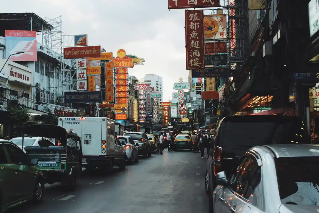 Bangkok Chinatown during the day with traffic, side streets, and shopfronts photo 3