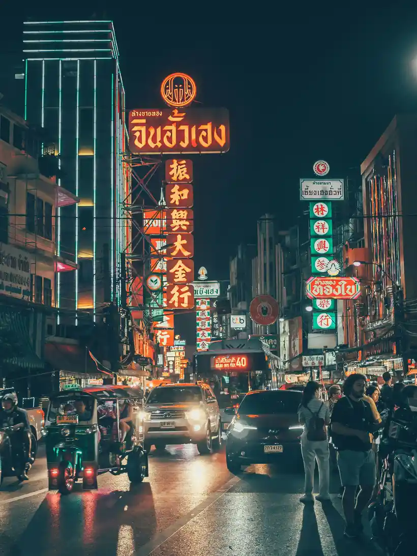 Yaowarat nightlife with neon signs, tuk-tuks, and rainy evening streets photo 2