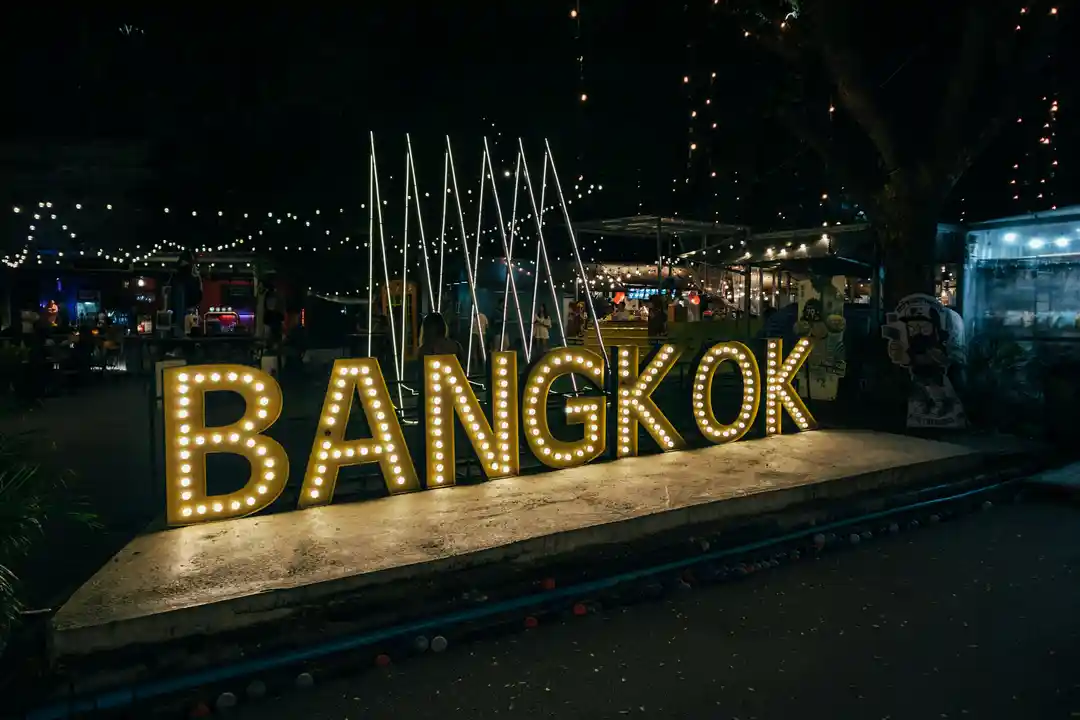 Illuminated Bangkok sign at a riverside night market