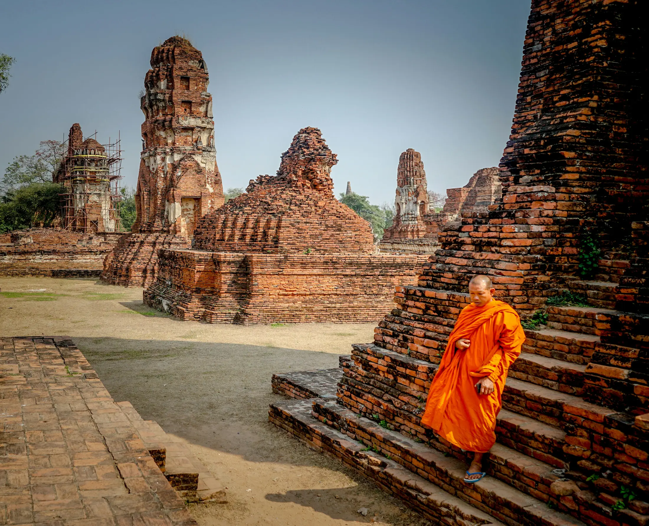 Monk walking through brick temple ruins in Ayutthaya