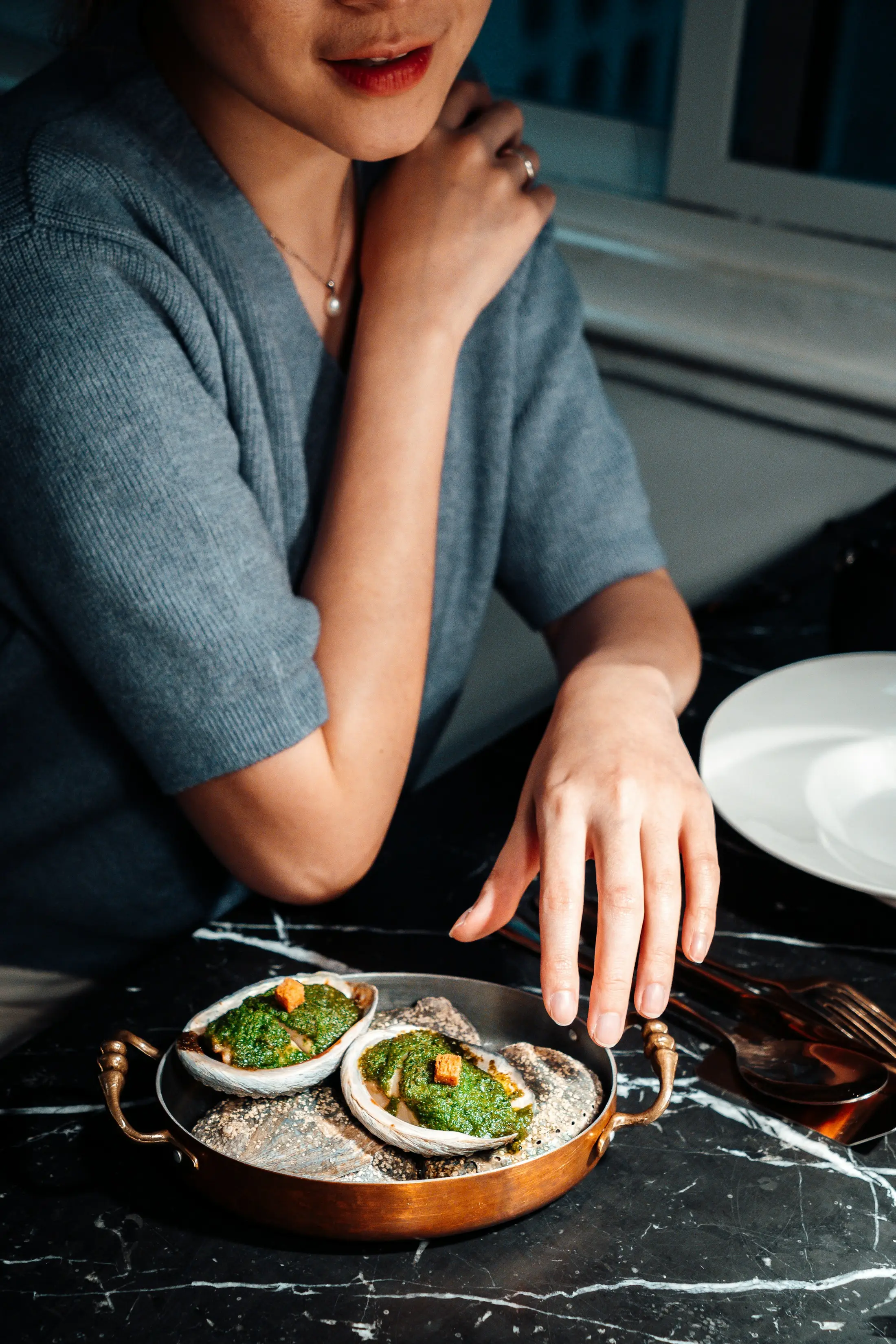 A fine dining guest with a plated oyster dish in Bangkok