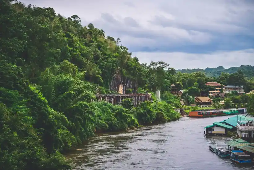 River Kwai railway, floating raft houses, and green hills in Kanchanaburi