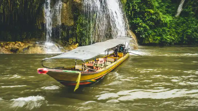 Waterfall and longtail boat in Sai Yok, Kanchanaburi